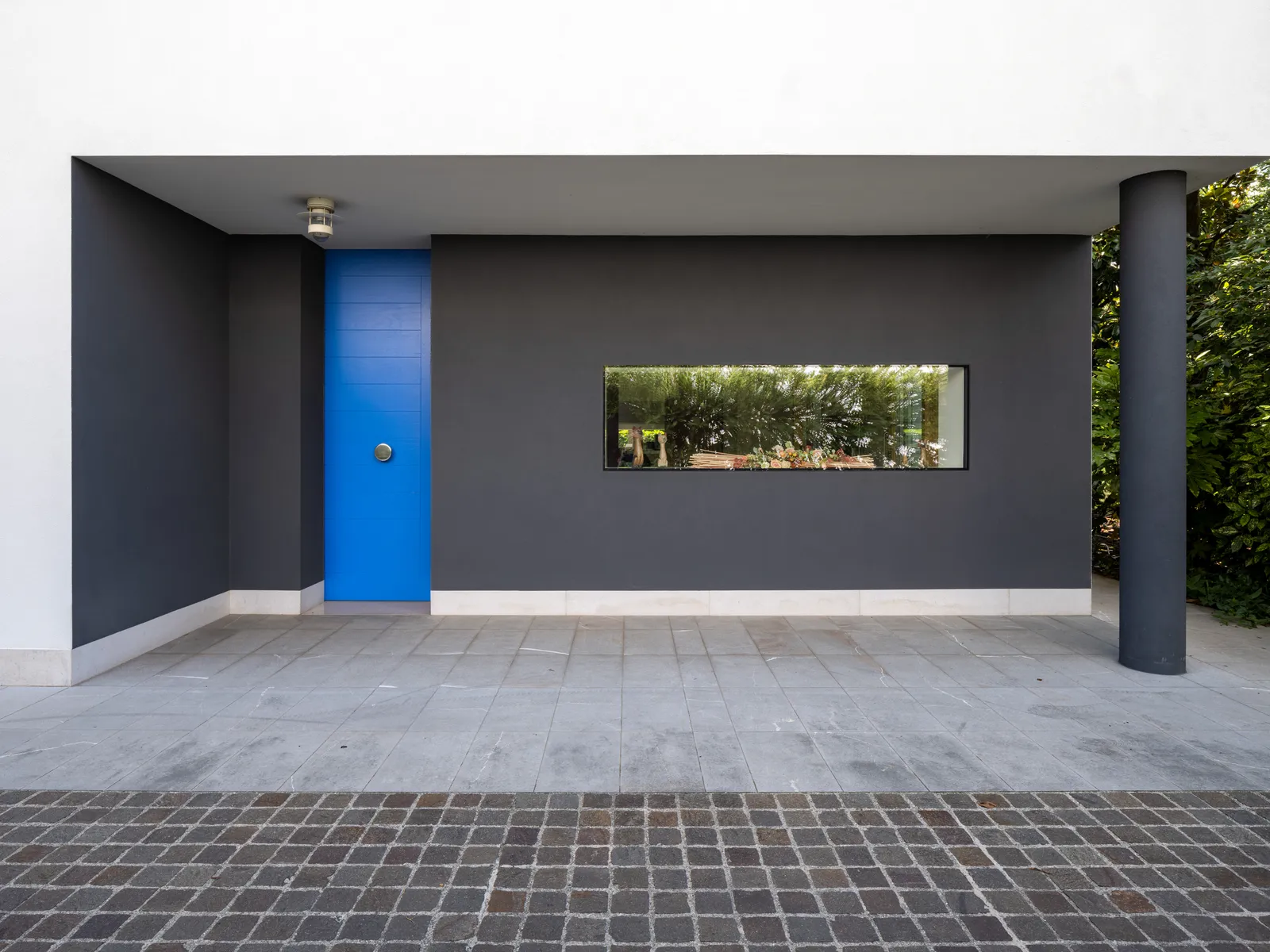 Ingresso della villa con portoncino blu cobalto e vetrata orizzontale
